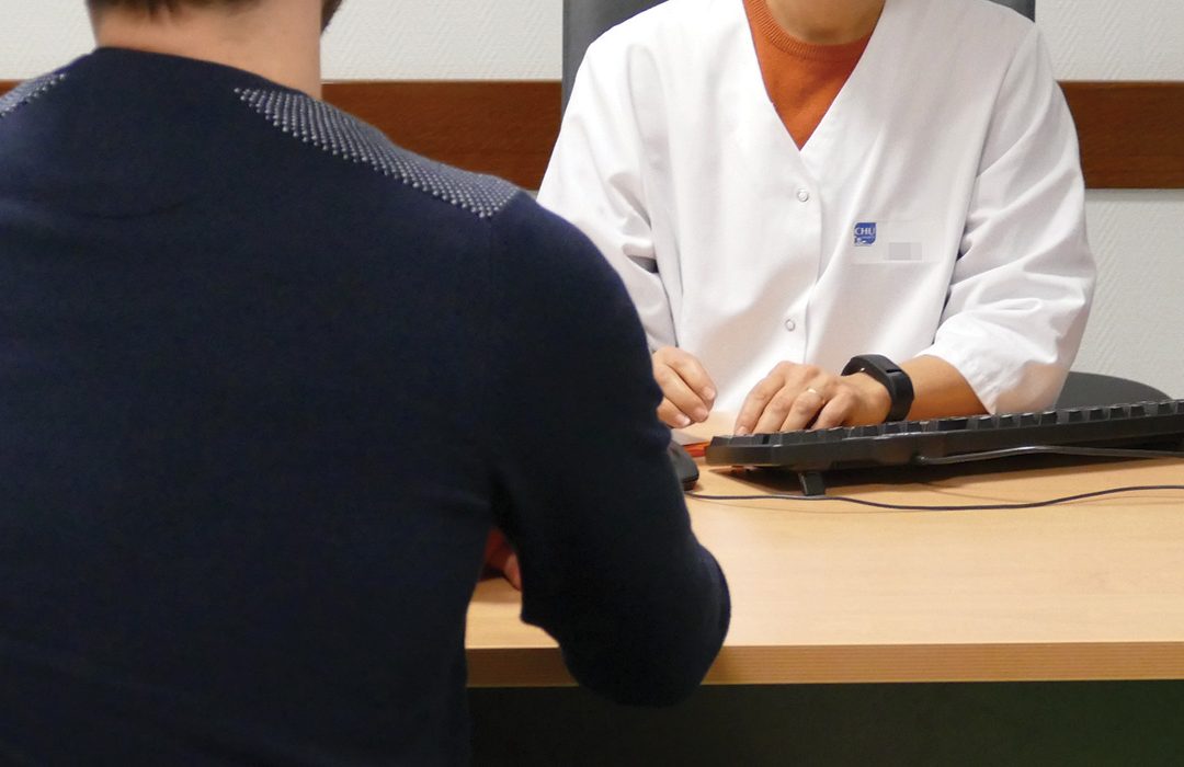 Photo d'une consultation à un bureau entre un patient et un soignant