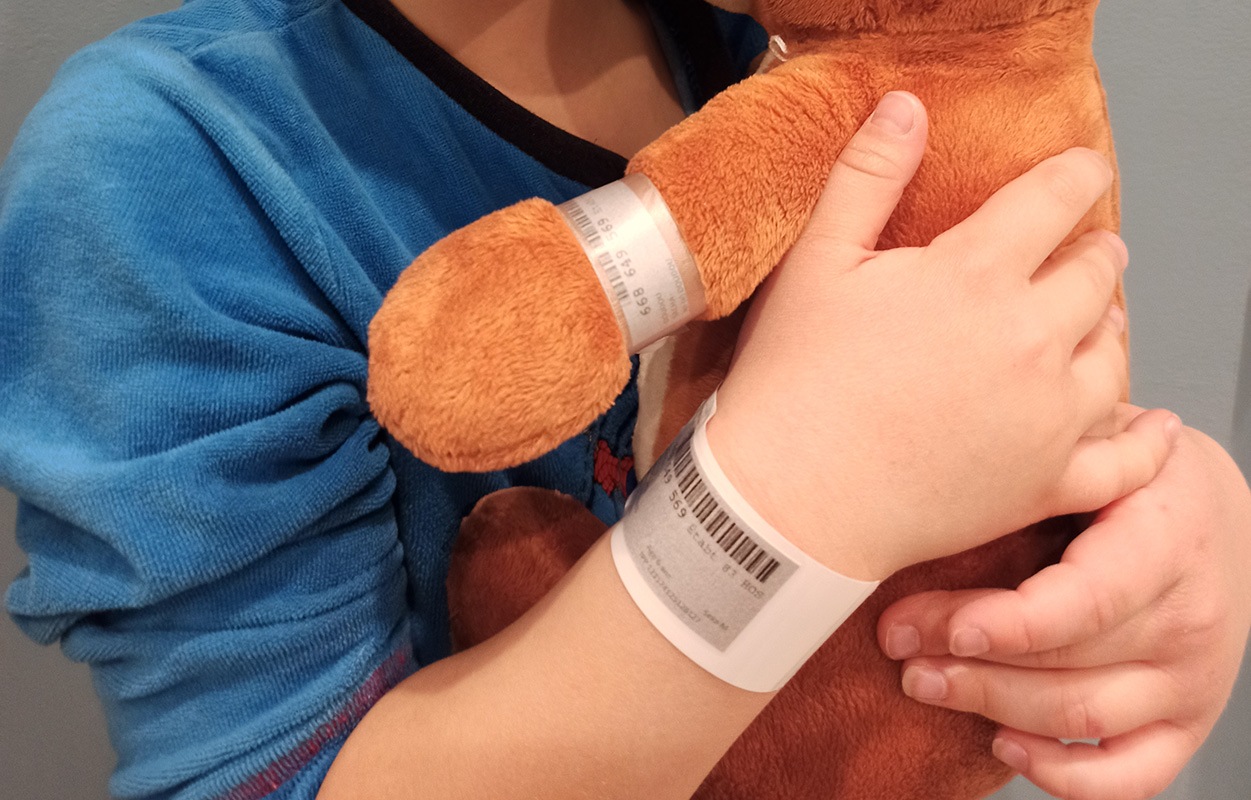 Photographie d'un enfant tenant un ours en peluche