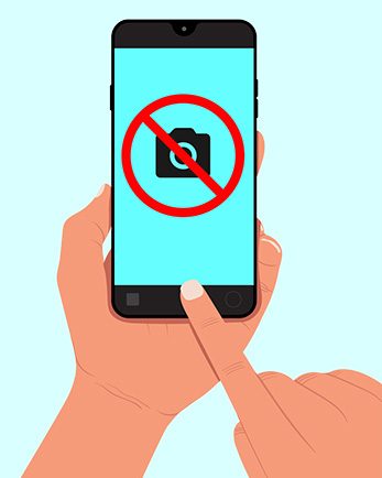 Illustration figurant une main tenant un smartphone affichant un pictogramme photo interdite