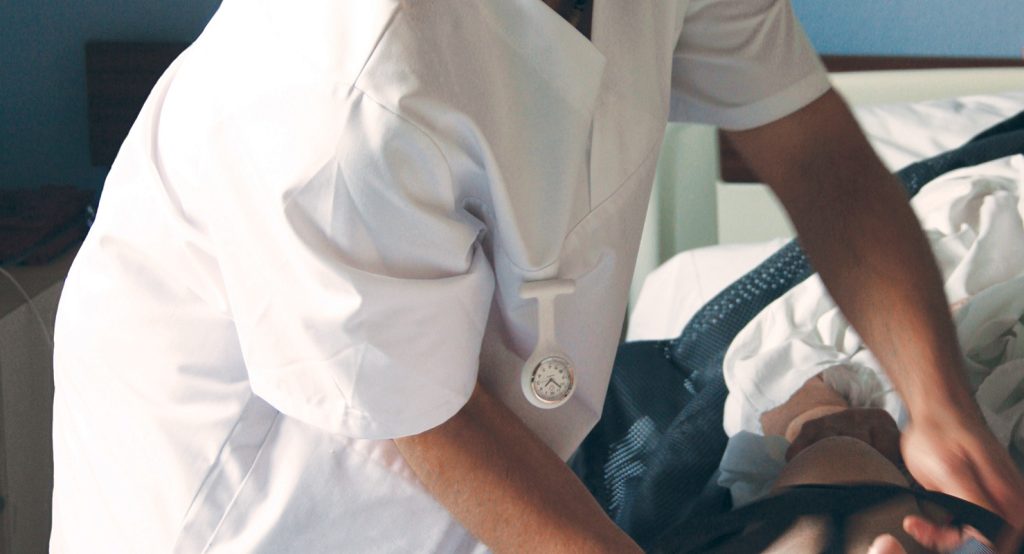 Photo d'un soignant s'occupant d'un patient alité