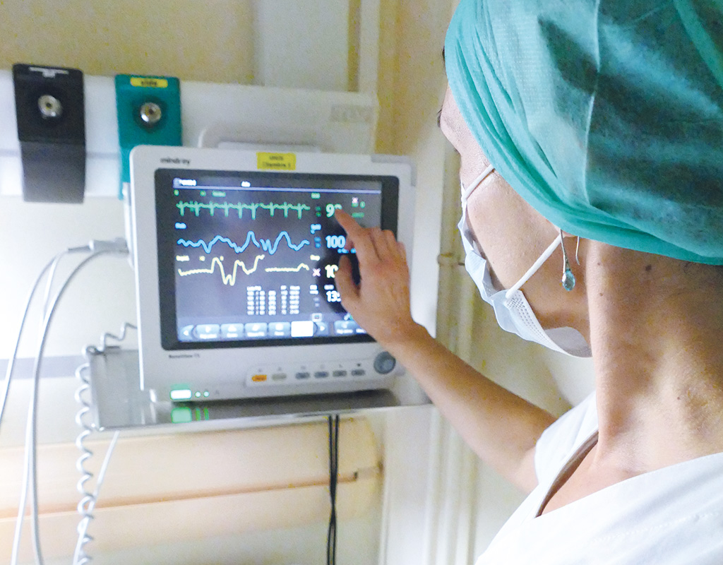 Photo d'une soignante contrôlant un écran de monitoring patient