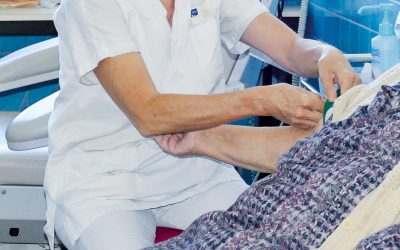 Photo d'une soignante qui pose une perfusion à une patiente