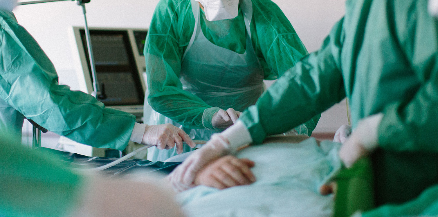 Photographie de plusieurs soignants autour d'un patient hospitalisé en réanimation