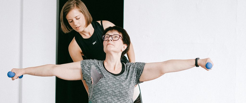 femme avec un coach entrain de réaliser des exercices de musculation