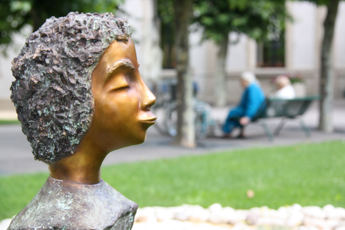 sculpture en bronze représentant un visage faisant un bisou aux visiteurs