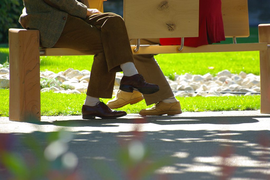 deux personnes échangent assises sur un banc du jardin
