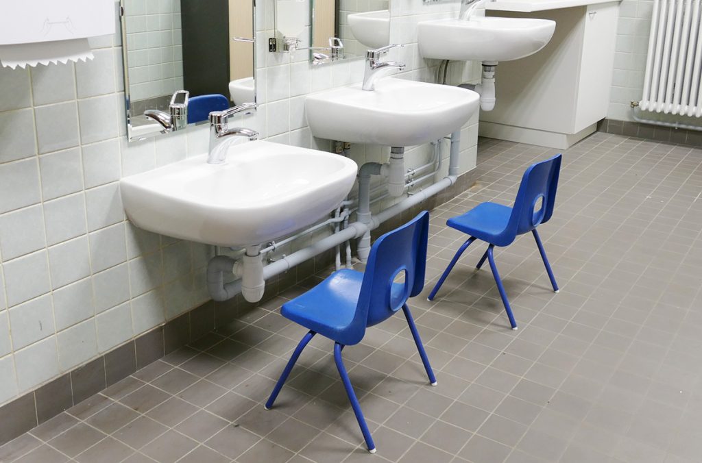 salle d'éducation aux soins bucco-dentaires avec lavabos adaptés à la hauteur des enfants