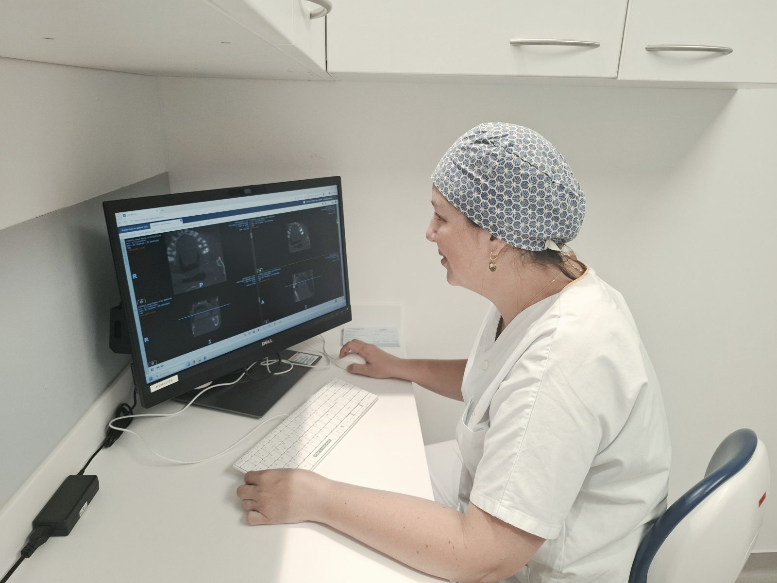 Une chirurgienne dentiste analyse les images d'une radio dentaire.