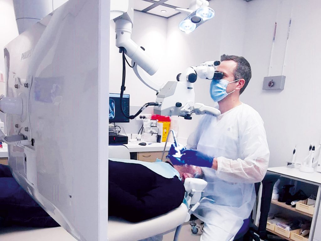 chirurgien dentiste qui réalise un soin dentaire sur une personne