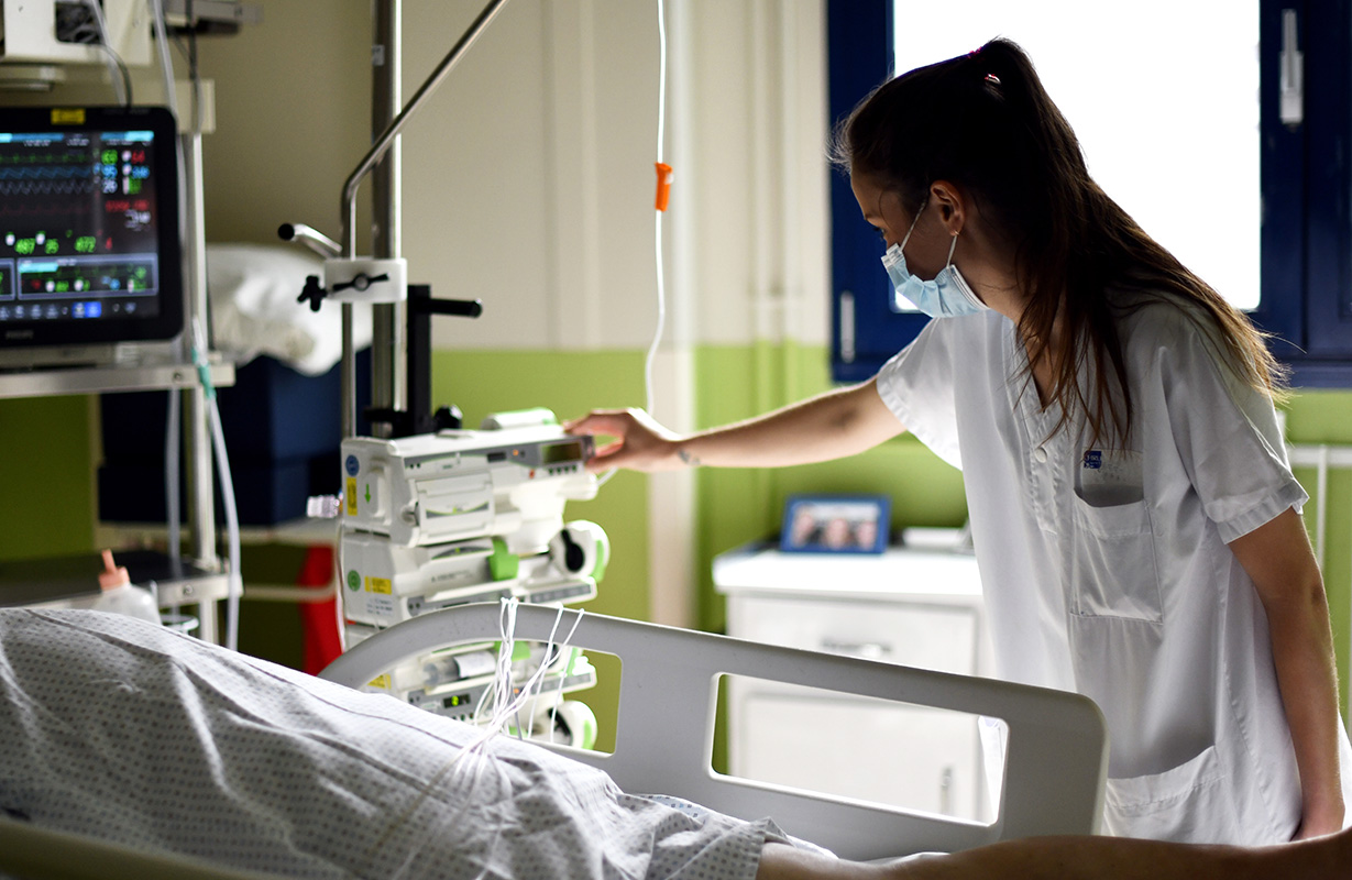 soignante auprès d'un patient en réanimation