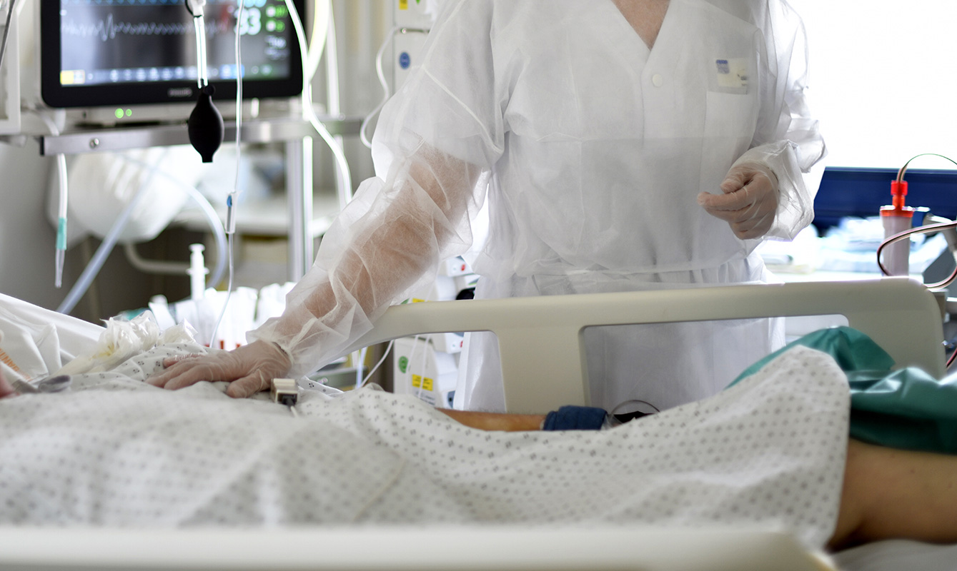 soignante auprès d'un patient en réanimation