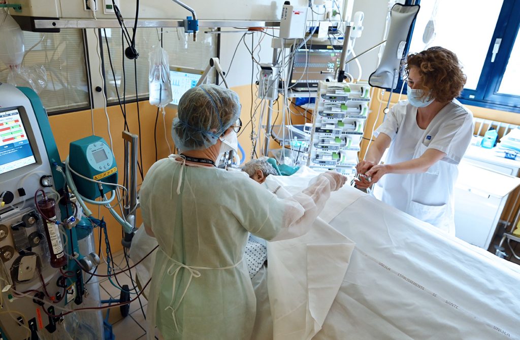 soignantes auprès d'un patient en réanimation