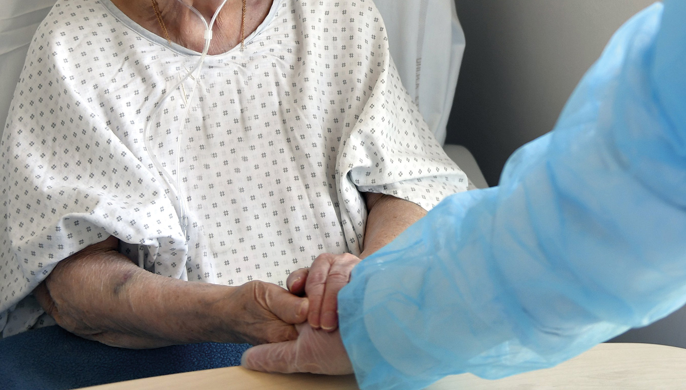 un médecin tient la main d'une patiente