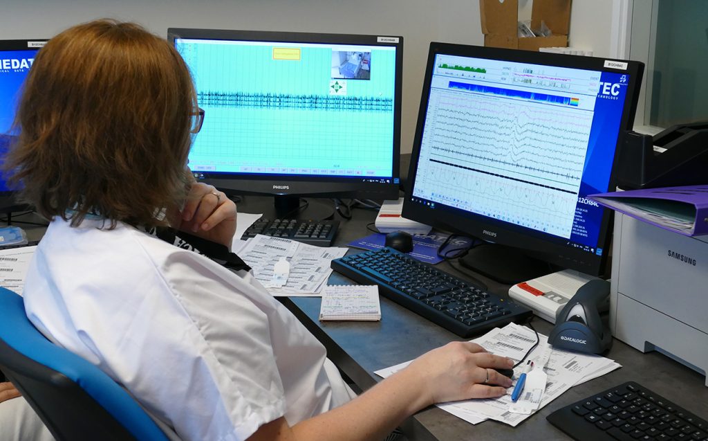 Photo d'une infirmière technicienne du sommeil qui vérifie des tracés sur un ordinateur