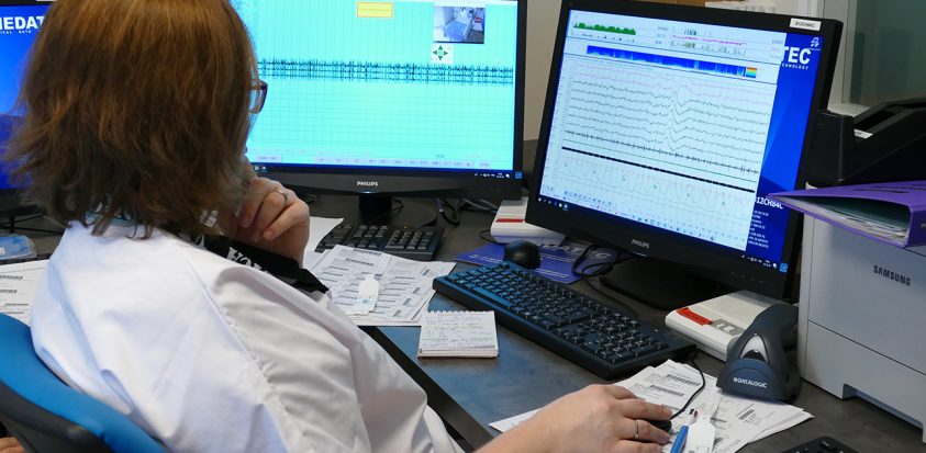 Photo d'une infirmière technicienne du sommeil qui vérifie des tracés sur un ordinateur
